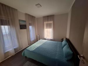 a bedroom with a bed and two windows at Offline Home in Balatonőszöd