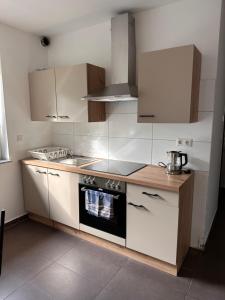 a kitchen with white cabinets and a stove top oven at AM Apartment 8 in Gronau