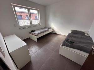 a bedroom with two beds and a window at AM Apartment 8 in Gronau