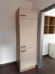a closet with white cabinets and a mirror at AM Apartment 8 in Gronau