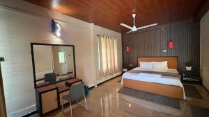 a bedroom with a bed and a desk and a mirror at Forest Garden Cottages in Deraniyagala