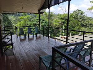 a balcony with chairs and a view of the forest at Forest Garden Cottages in Deraniyagala