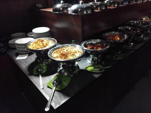 a buffet with several bowls of food on a table at Forest Garden Cottages in Deraniyagala +5 photos