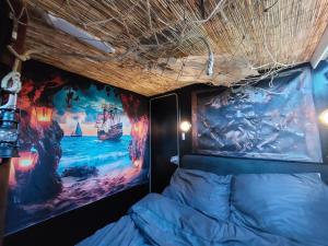 a room with a bed with a painting on the wall at L'évasion - Pairi Daiza - Insolite in Chièvres