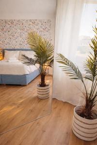 a bedroom with two potted plants in front of a mirror at Suites in Brunn am Gebirge in Brunn am Gebirge