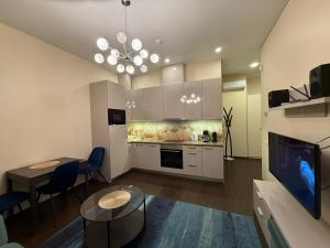 a living room with a table and a kitchen at Kęstučio 66 apartamentai in Kaunas