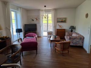 a living room with a couch and chairs and a tv at Jagdschloss Friedrichsthal in Waldeck