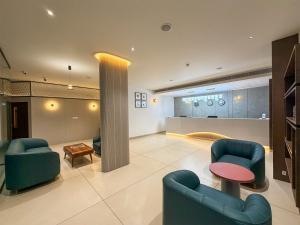 a lobby with two blue chairs and a table at Hotel Grand Residency in Mannārakkāt