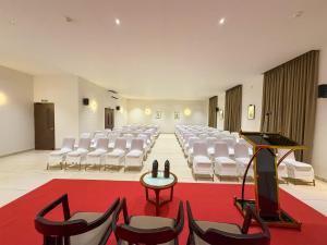 a large room with white chairs and a red carpet at Hotel Grand Residency in Mannārakkāt