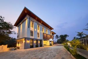 a large white house with a driveway at Hotel Grand Residency in Mannārakkāt