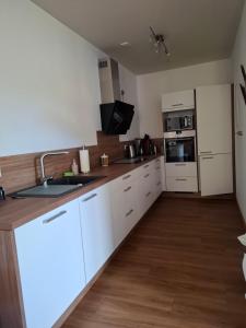 a kitchen with white cabinets and a sink at Jagdschloss Friedrichsthal in Waldeck +5 photos