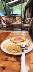 a plate of food on a wooden table with a fork at Kizumba House in Arusha