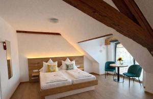 a bedroom with a bed and a table and chairs at Hotel Zum Klosterfischer in Blankenburg