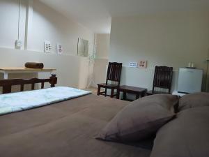 a bedroom with a bed with two chairs and a table at บ้านในสวนรีสอร์ทBannnaisuan Resort in Prachuap Khiri Khan