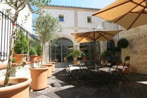 a patio with a table and chairs and umbrellas at Gîte Étoiles d'Orion 6 chambres in Marsolan