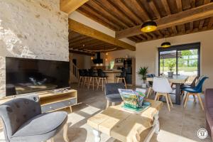 a living room with a large tv and a table at Gîte de Savenay in Aunay-en-Bazois