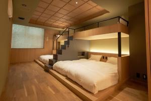 a bedroom with two bunk beds and a staircase at Apartment Hotel UCHIWA STAY Osaka NAMBA in Osaka