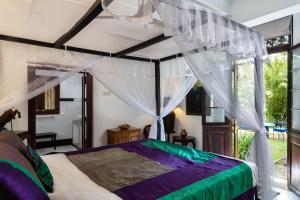 a bedroom with a bed with a canopy at Clingendael Weligama in Weligama