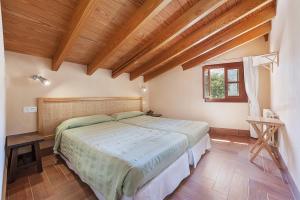 a bedroom with a large bed and a wooden ceiling at Villa Es Barracar Caimari in Caimari +19 photos