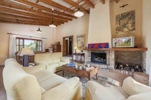 a living room with white furniture and a fireplace at Villa Es Barracar Caimari in Caimari