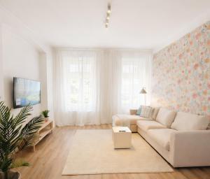 a white living room with a couch and a table at Suites in Brunn am Gebirge in Brunn am Gebirge