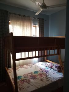 a wooden bed in a room with a window at Same Harmony Hideaway in Zame