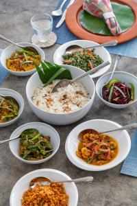 a table topped with white bowls of different food at Clingendael Weligama in Weligama