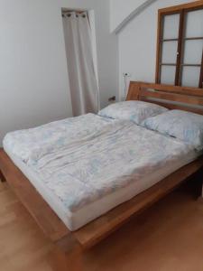 a bed with a wooden frame in a bedroom at Neue Wohnung am Fluss in Losenstein