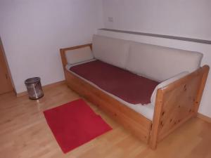 a wooden bed in a room with a red rug at Neue Wohnung am Fluss in Losenstein