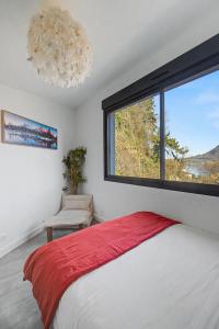 a bedroom with a bed and a large window at La Roche & Le Lac in Sévrier