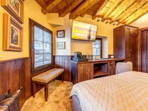 a bedroom with a bed and a desk and a window at Pipers Lodge in Shiroka Laka