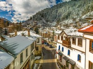 a small town in the mountains with snow covered roofs at Pipers Lodge in Shiroka Laka