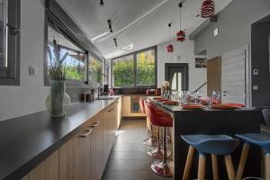 a kitchen with a black counter and some chairs at La Roche & Le Lac in Sévrier