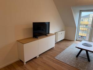 a living room with a flat screen tv on a white cabinet at Stadtwohnung Bocholt in Bocholt