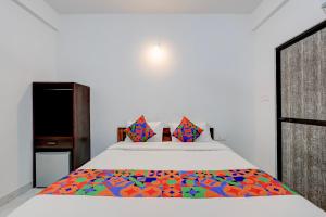 a bedroom with a bed with a colorful blanket on it at FabHotel Crystal Bay Baga in Baga