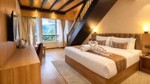 a bedroom with a large bed and a large window at Yashshree Dewathang Resort in Lachung