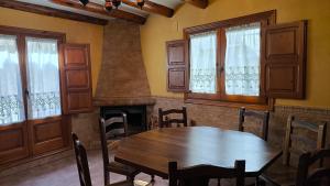 a dining room with a wooden table and a fireplace at Casa Mola in Forcall