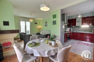 a kitchen and living room with a table and chairs at Le jardin in Plestin-les-Grèves +28 photos