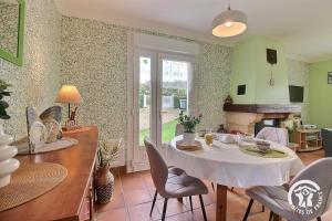 a kitchen and dining room with a table and chairs at Le jardin in Plestin-les-Grèves