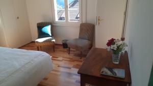a bedroom with a bed and a table with flowers on it at Krone Trogen in Trogen