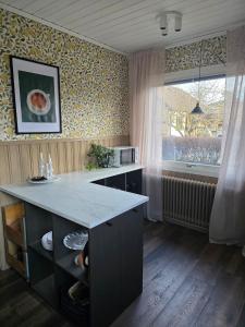 a kitchen with a counter and a large window at Stora Tegelhuset in Borlänge