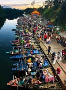 a crowd of people standing aroundocked boats in the water at Kitjamyhome1 in Hat Yai