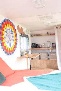 a room with a table and a painting on the wall at Caravane cocooning in Saint-Martin-des-Noyers +4 photos
