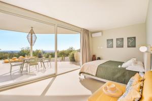 a bedroom with a bed and a balcony with a table at Fior di Noto in Noto