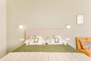 a bedroom with a bed with white and green pillows at Fior di Noto in Noto