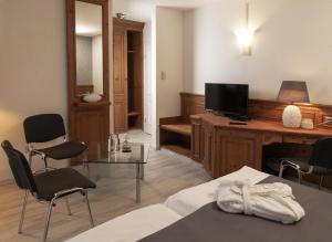 a living room with a tv and a table and chairs at Hotel Haus Gimken in Essen