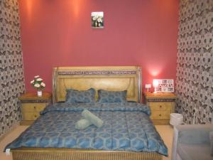 a bedroom with a blue bed with blue pillows at العين الهيلي مصباح بيت14 in Al Ain