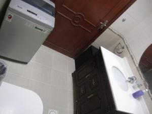 a bathroom with a toilet and a sink and a cabinet at العين الهيلي مصباح بيت14 in Al Ain +10 photos
