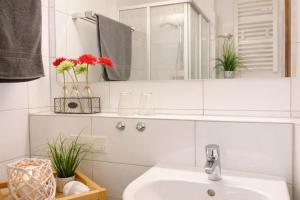 a white bathroom with a sink and a mirror at Ole's BergSuite in Braunlage +10 photos