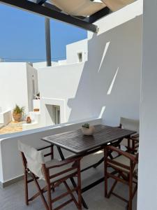 a patio with a wooden table and chairs at Aegean Muses in Leipsoi